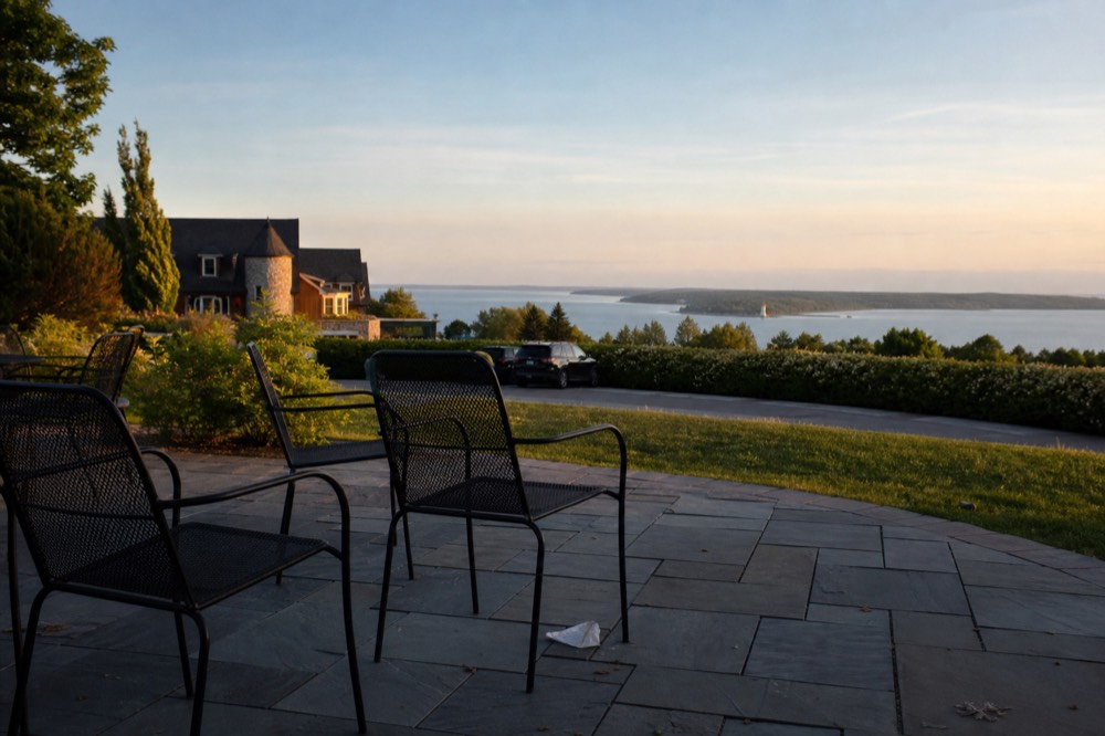 A winery terrace with chairs and a view of a bay