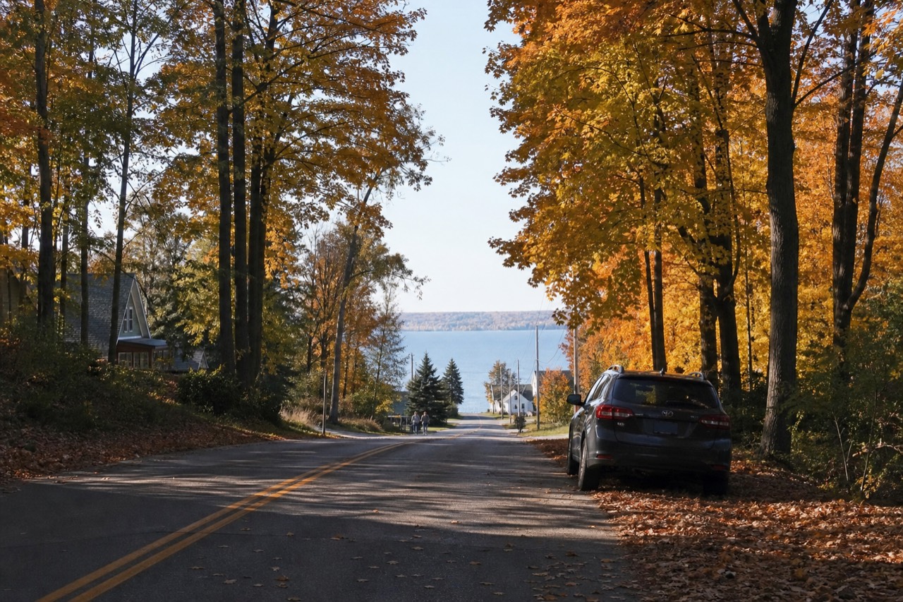 A tree-lined peninsula road above a bay in autumn
