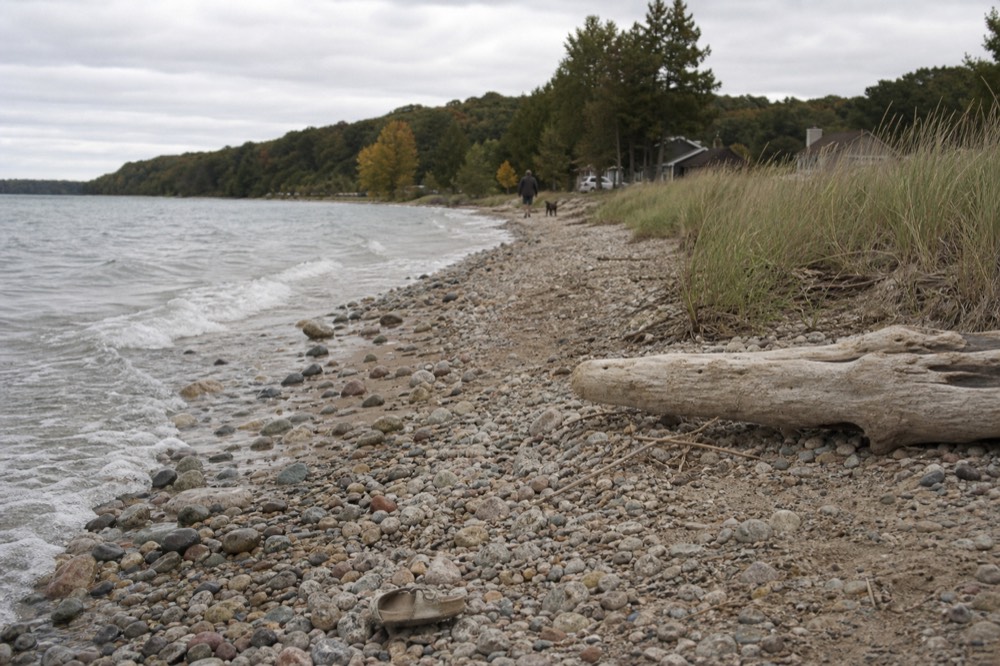 A quiet Lake Michigan shoreline with smooth stones at the waterline