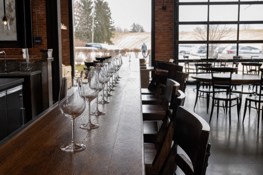 A tasting room bar with a row of wine glasses waiting to be poured