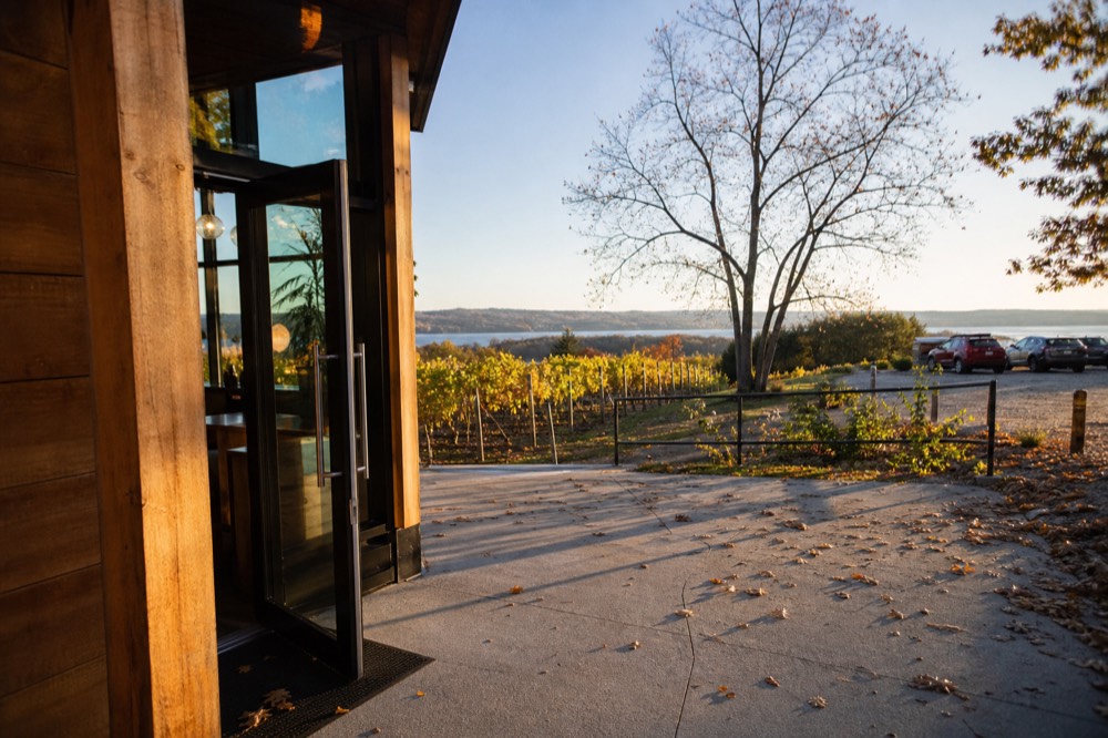 A winery tasting room entrance with vineyards behind it on Old Mission Peninsula